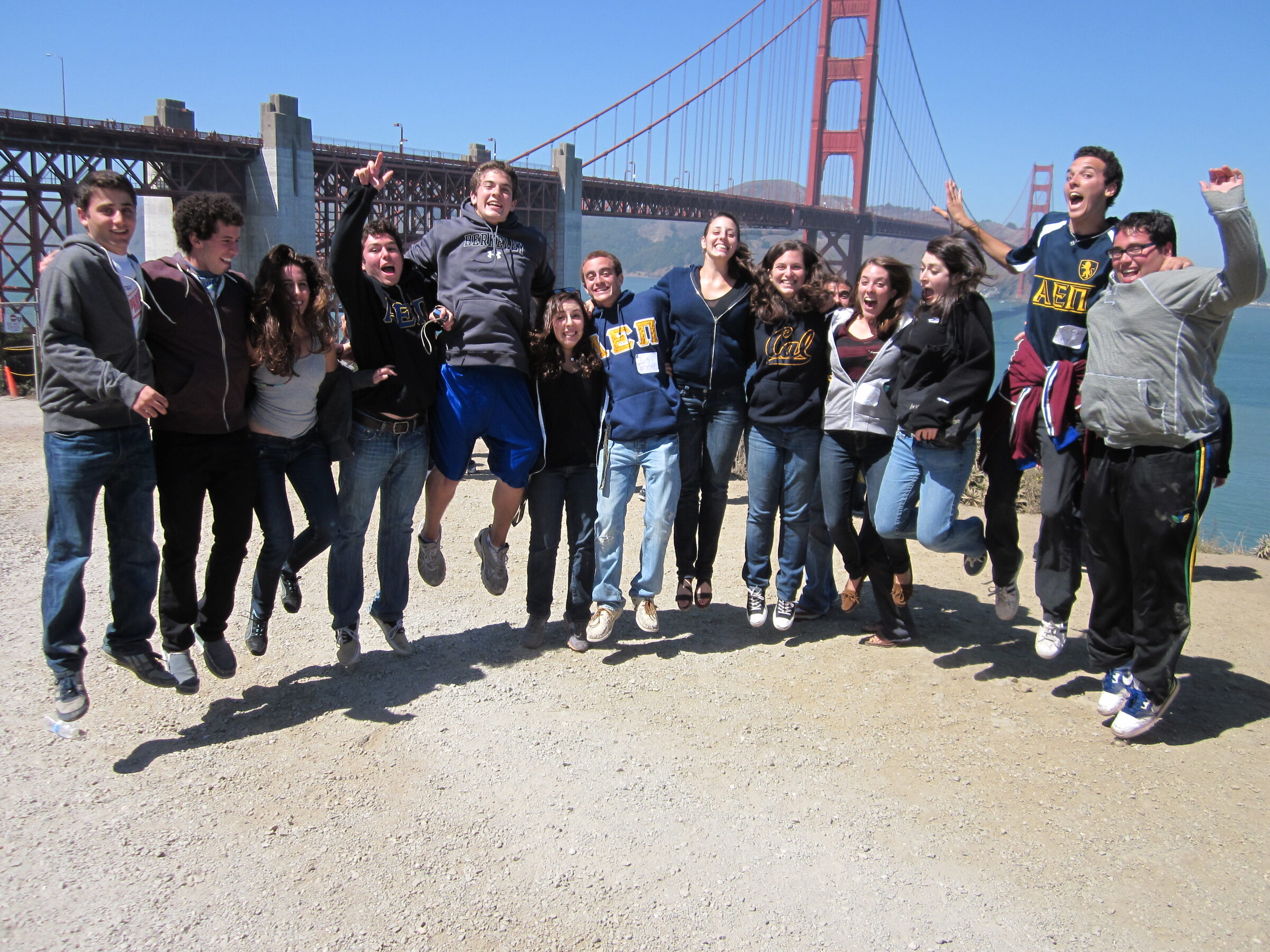 Students leaping into the air together in front of the Golden Gate Bridge