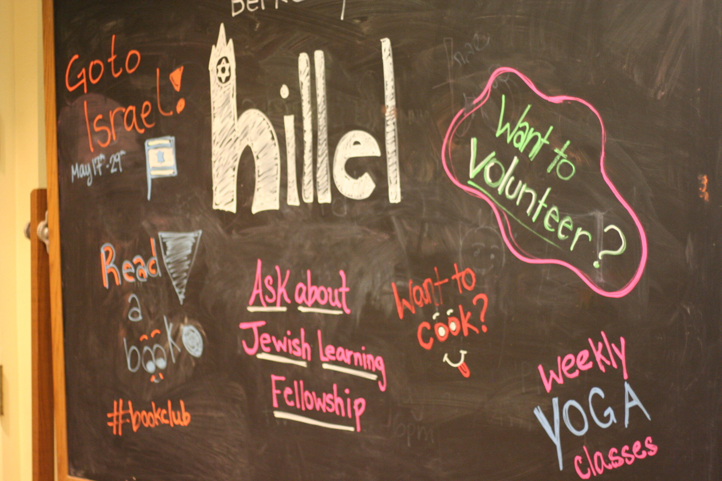 A chalkboard covered in colorful hand-lettering listing Berkeley Hillel activities