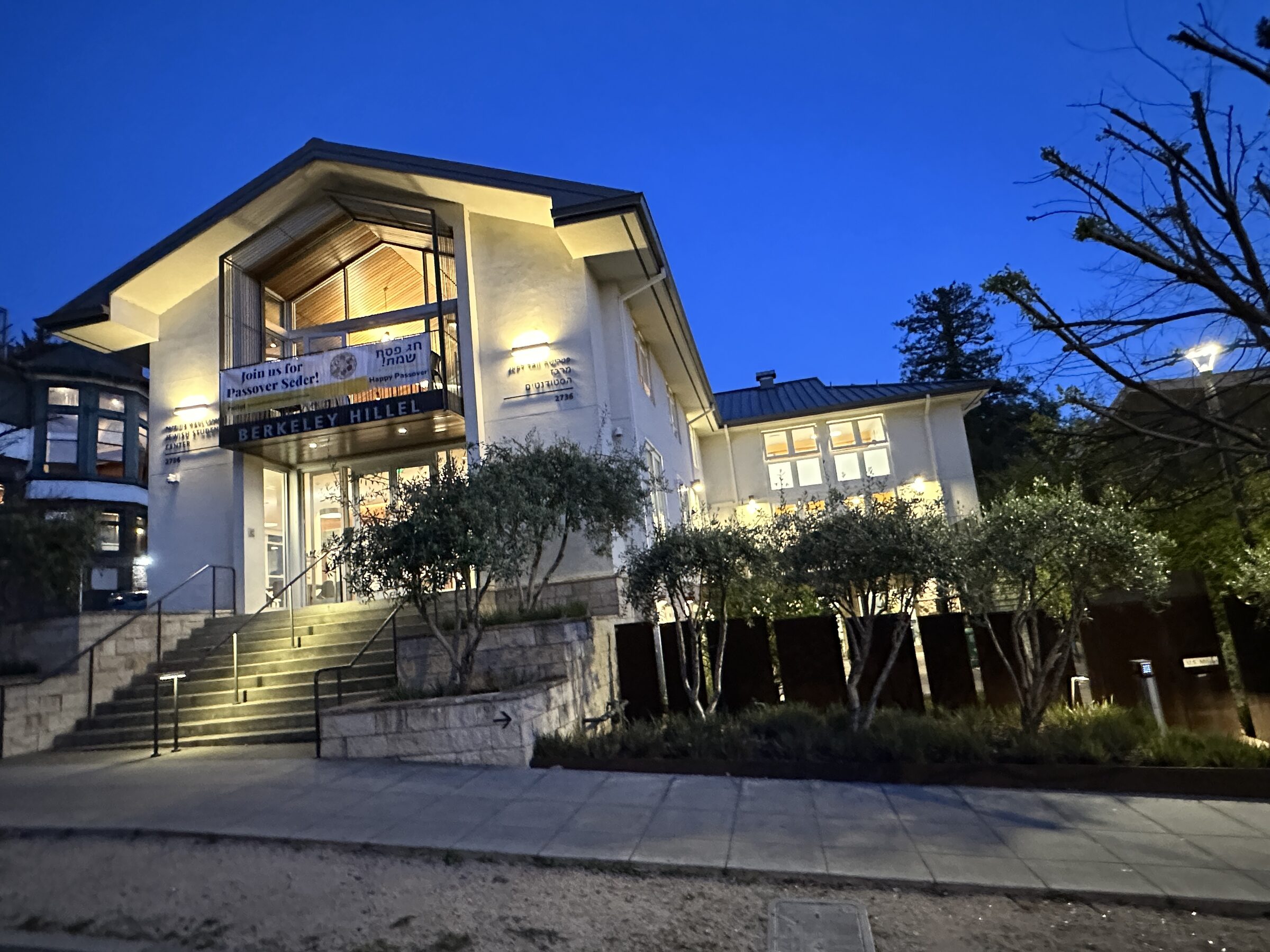 The renovated Berkeley Hillel building lit from within at dusk